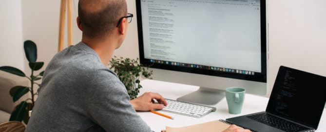 Programmer, working behind the desk, googling and coding at the same time